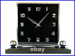 A large art deco mantle clock in black celluloid with chrome surround