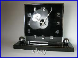 A large art deco mantle clock in black celluloid with chrome surround